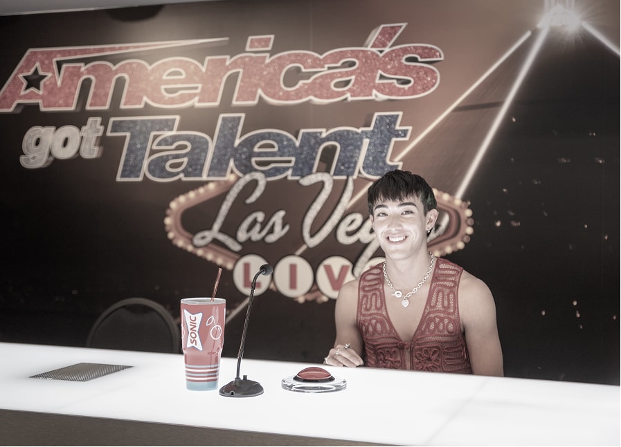 An America's Got Talent contestant sitting behind a desk