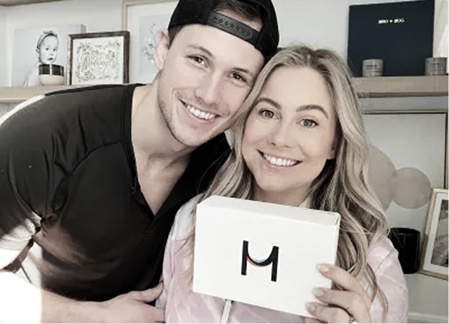 Two people holding a box and smiling